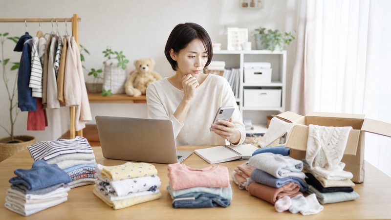 子ども服の買取方法を比較しながら売却先を選ぶ様子